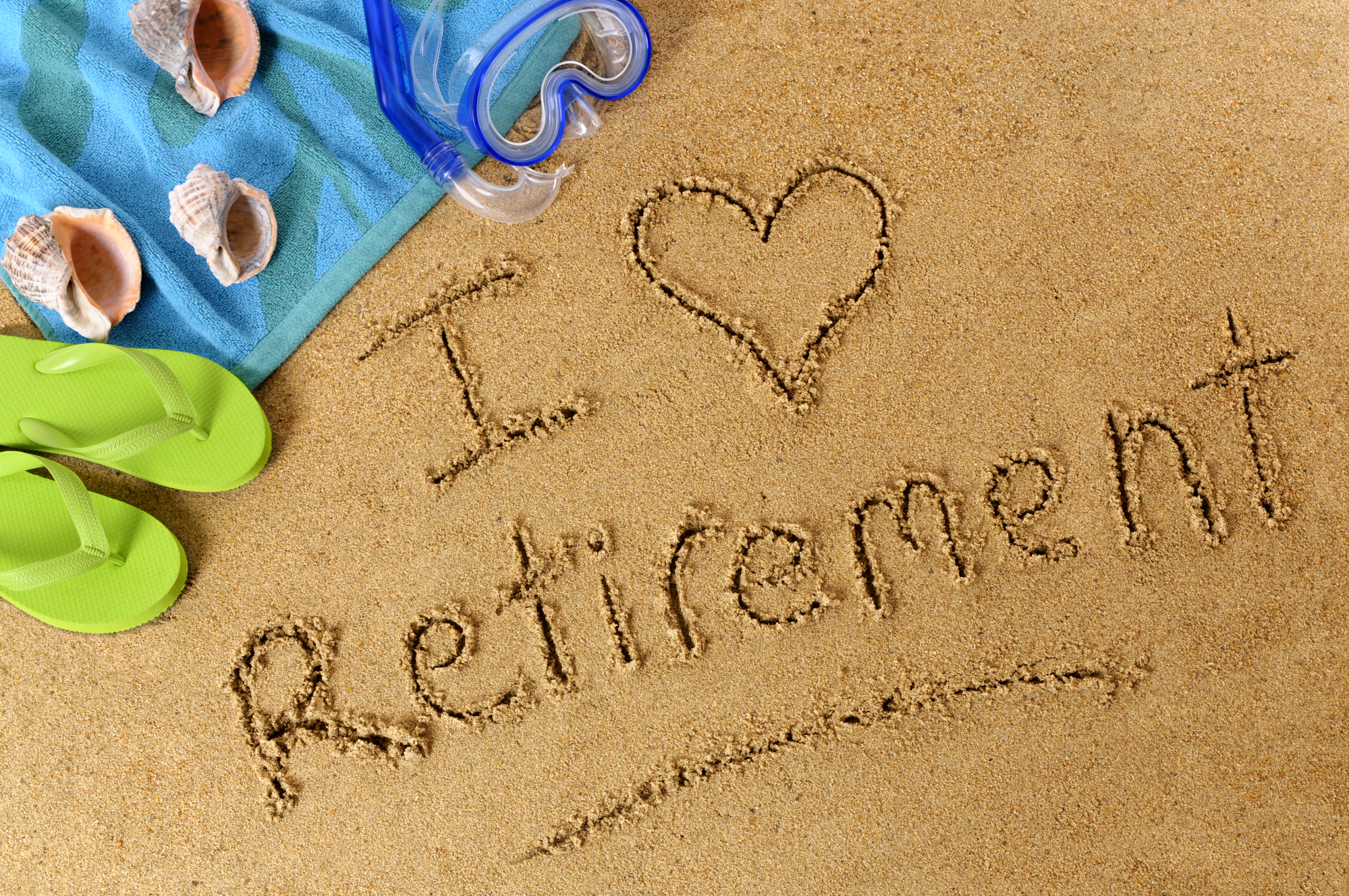 A photo of beach equipment sitting on wet sand with the words "I Heart Retirement" written in it